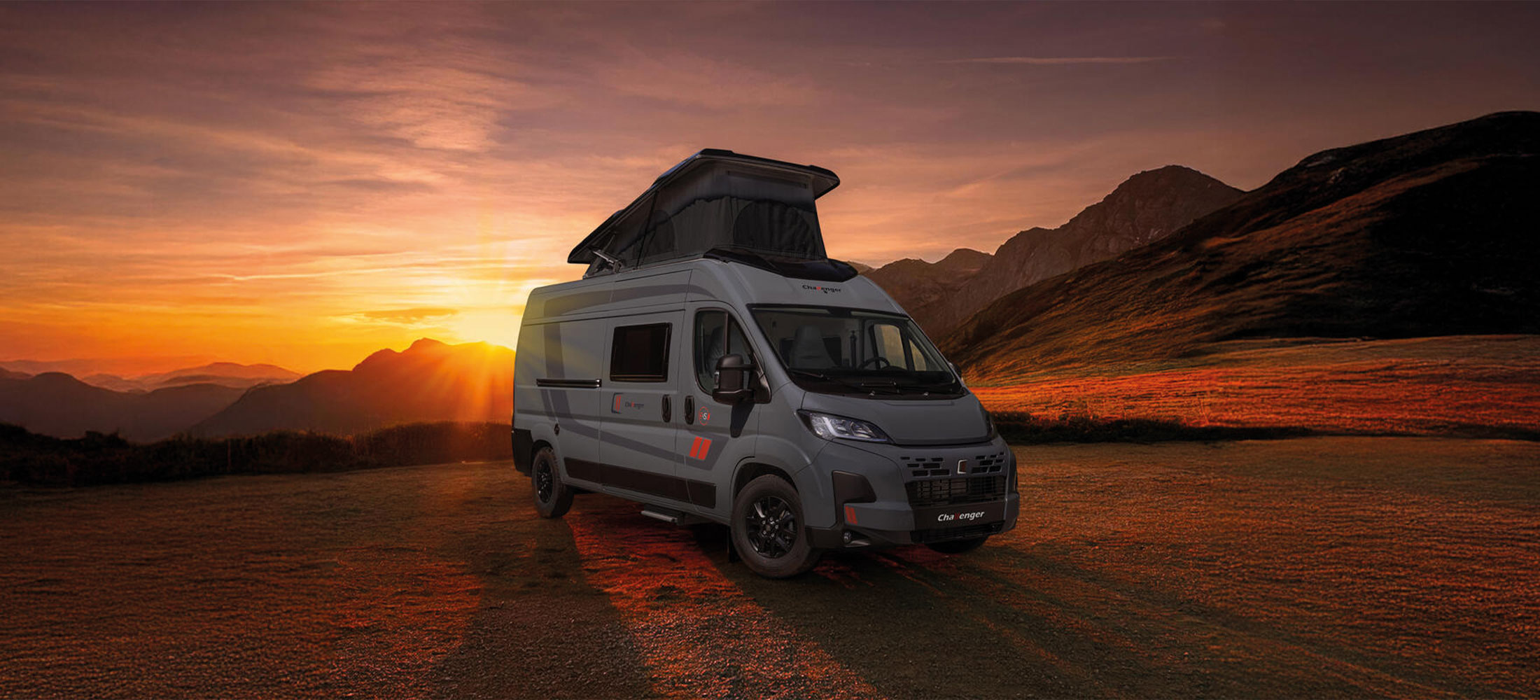 Camper Westfalia mit Sonnenuntergang im Hintergrund