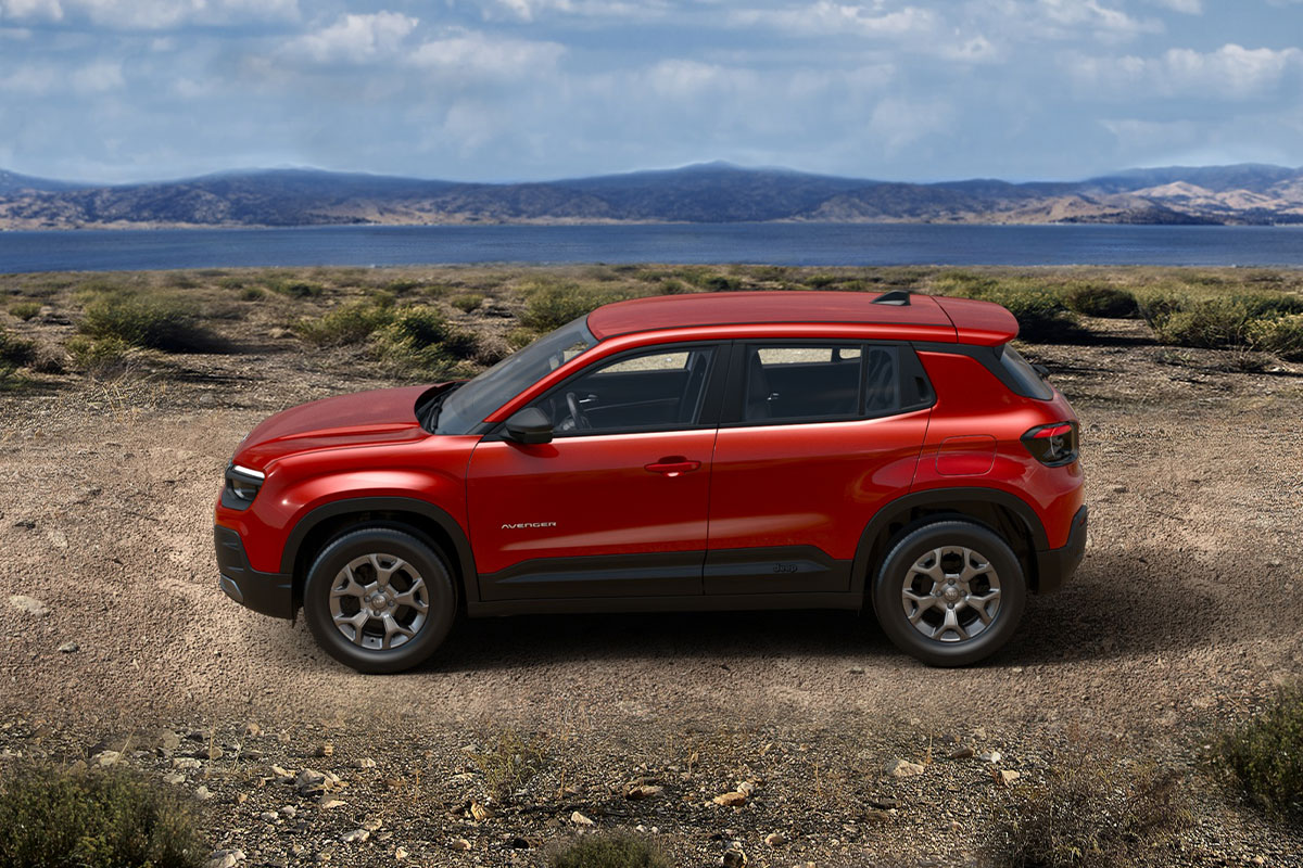 Jeep Avenger in Ruby Red von der Seite vor einer Landschaft