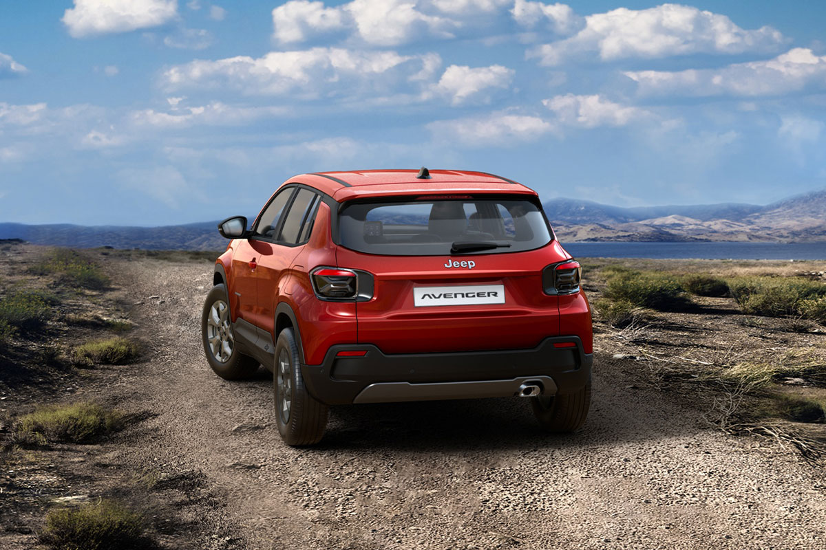 Jeep Avenger in Ruby Red von hinten vor einer Landschaft